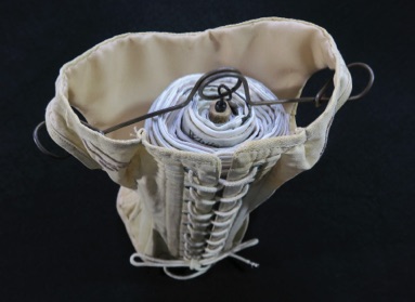 Unique artist book corset Conventional Burdens Corset with rolled book inside - top view from hanger